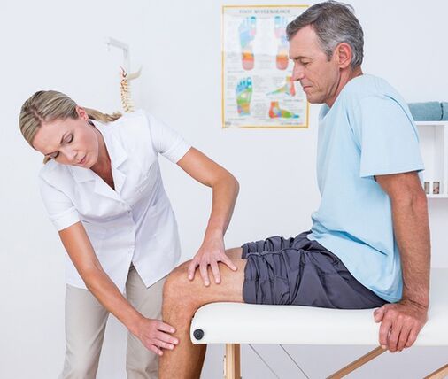 Zdravnik opravi vizualni pregled in palpacijo bolnika z bolečino v kolenu